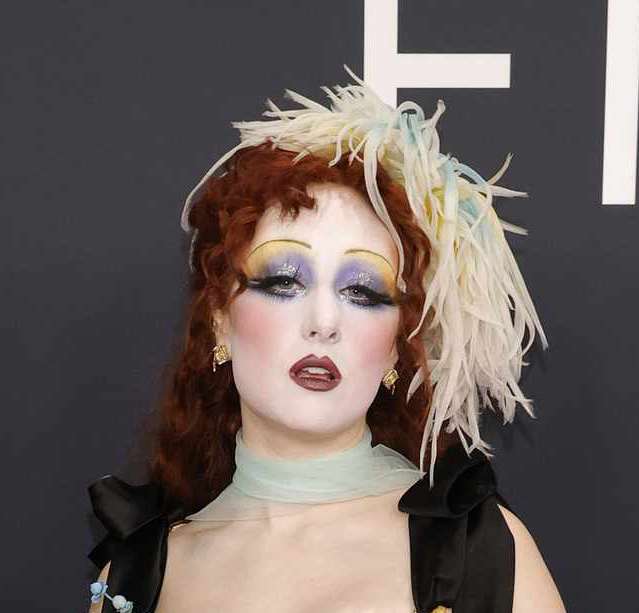 Chappell Roan captures attention at the 2025 Grammys with a unique hairstyle and makeup that embody her boundary-pushing style on the red carpet.