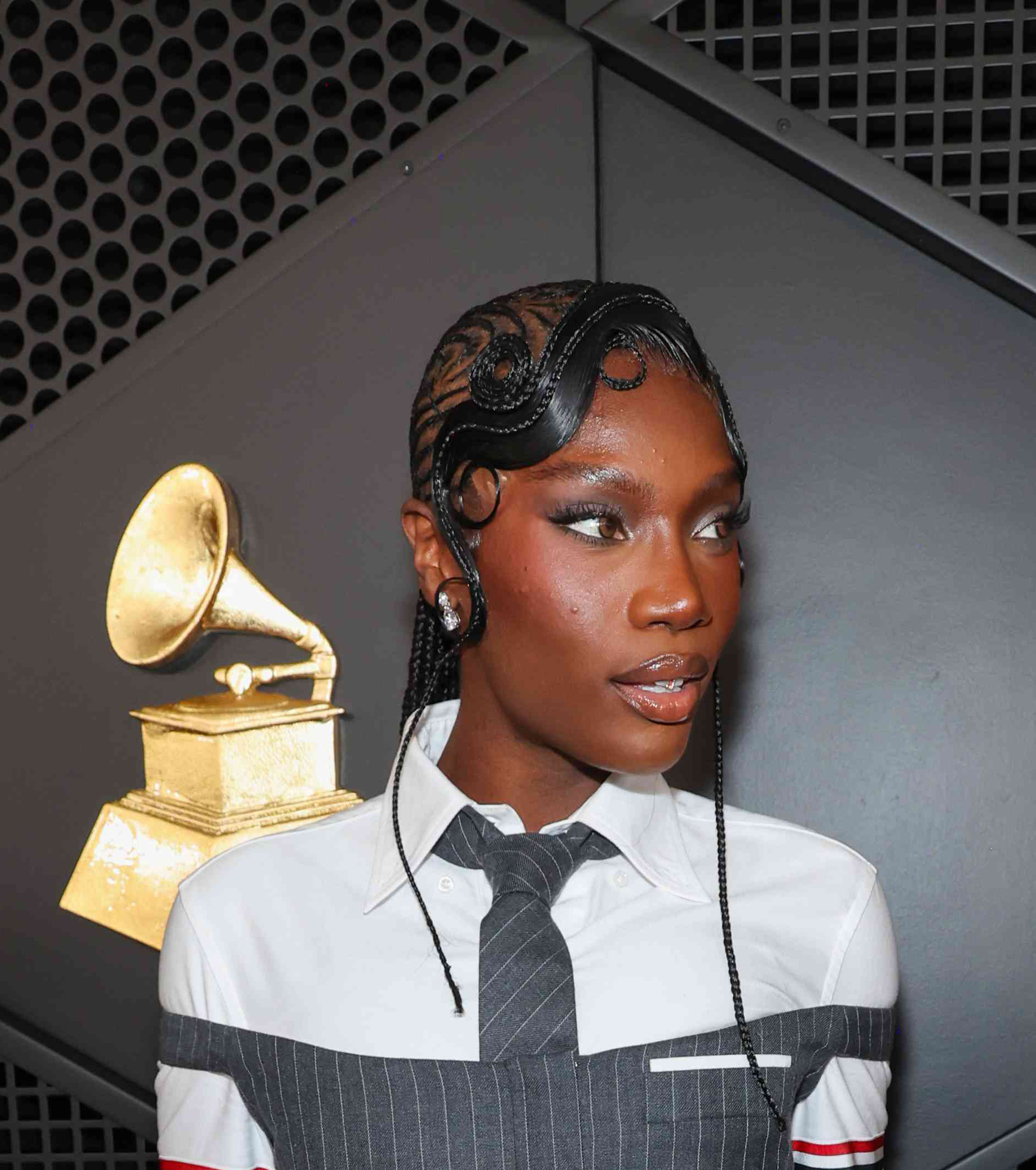 Doechii stuns on the red carpet with her striking hairstyle and confident pose reflect her unique style and artistic presence at the 2025 Grammys
